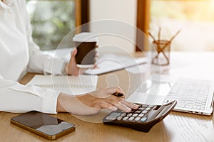 Close up business hands using calculator for calculating financial data report of company