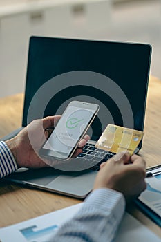 Close-up of business holding credit card to check account balance Use an online banking app on your laptop. online payment typewri