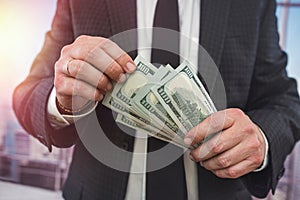 close up business man in classik black siut hold and check dollar