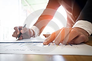 Close up of business man hand working on graph sheet