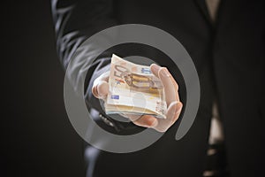 Close up of a business man hands offering money.