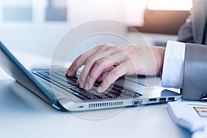 Close up of business man hands typing on laptop computer