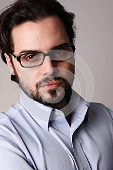 Close-up of business man standing in corporate portrait isolated on white wall.