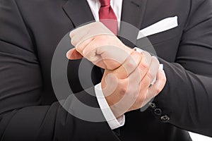 Close-up of business man standing holding wrist like hurting