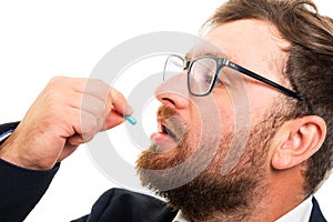 Close up of business man taking pill