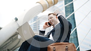 Close up of business man talking phone and celebrate successful project. Urbane.