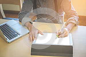 Close-up of business man using tablet and computer to working financial data.