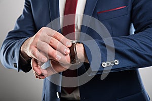 Close-up of business man wearing suit checking wrist watch