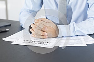 Close up of business manager signing document on table.