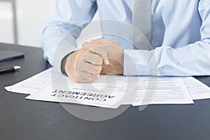 Close up of business manager signing document on table.