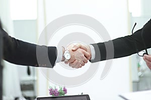 Close up.business men shaking hands on blurred background office