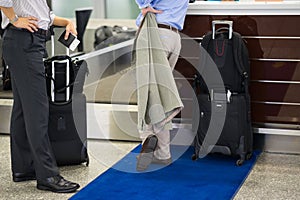 Close up business men talking at check-in counter at airport