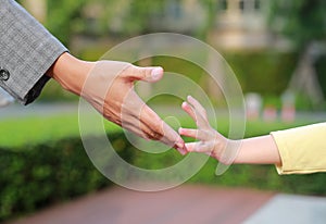 Close-up business mother and daughter hands reaching to each other