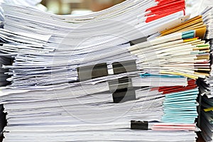 Close up of business papers stack on desk. Pile of unfinished documents on office desk