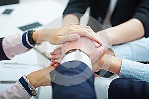 Close-up of business partners making pile of hands.