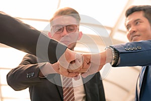 Close-up of business partners making pile of hands at meeting