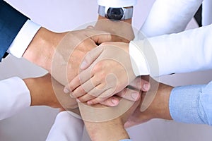 Close-up of business partners making pile of hands at meeting