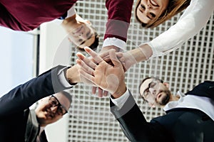 Close-up of business partners making pile of hands at meeting. Team work.