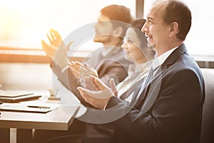 Close-up of business people clapping hands. Business seminar concept in office