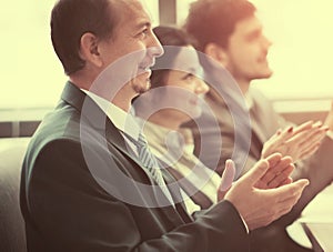 Close-up of business people clapping hands. Business seminar concept in office
