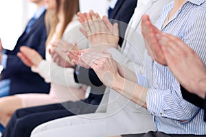 Close up of business people hands clapping at conference