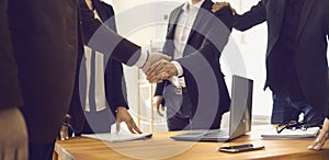 Close up of business people shaking hands in the office to confirm their partnership.