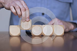 Close up of a business person arranging large wooden blocks. Business strategy and solutions