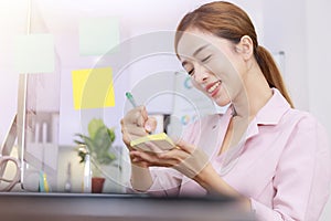 Close up business start up successful smile woman writing note on post-it at office. Businesswoman brainstorm writing note on