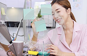 Close up business start up successful smile woman writing note on post-it at office. Businesswoman brainstorm writing note on blue