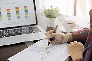 Close up Business strategy analysis. Businessman, accountant holding pen working on laptop computer, accounting financial business