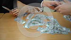 Close-up of a business team hands takes hundred dollar bills at a table. close-up. a large amount of money. 4 k Greedy