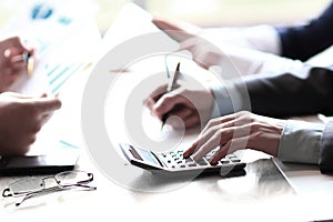 Close up. business team makes calculations using a calculator