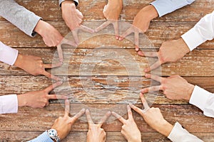 Close up of business team showing victory gesture