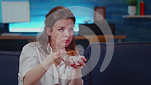 Close up of business woman eating asian food at TV