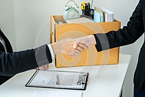 Close up of business woman employee in suit shaking hands with boss after signing on resignation letter