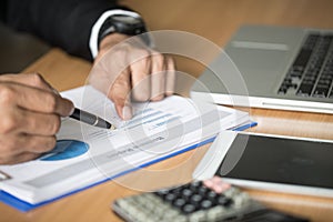 Close up of business woman hand working on laptop computer with financial business graph information, analyzing investment charts