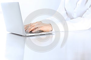 Close-up of business woman hands typing on laptop computer. Secretary at work in office