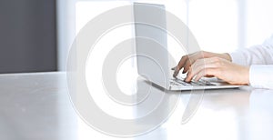 Close-up of business woman hands typing on laptop computer. Secretary at work in office