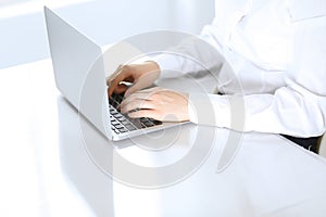 Close-up of business woman hands typing on laptop computer. Secretary at work in office