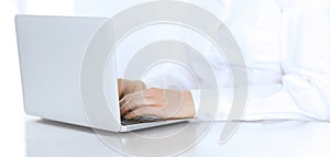 Close-up of business woman hands typing on laptop computer. Secretary at work in office