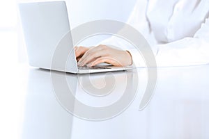 Close-up of business woman hands typing on laptop computer. Secretary at work in office