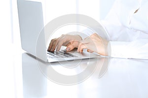 Close-up of business woman hands typing on laptop computer. Secretary at work in office