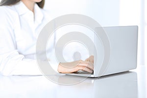 Close-up of business woman hands typing on laptop computer. Secretary at work in office