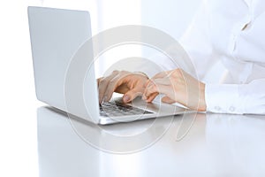 Close-up of business woman hands typing on laptop computer. Secretary at work in office