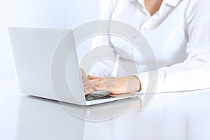 Close-up of business woman hands typing on laptop computer. Secretary at work in office