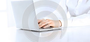 Close-up of business woman hands typing on laptop computer. Secretary at work in office