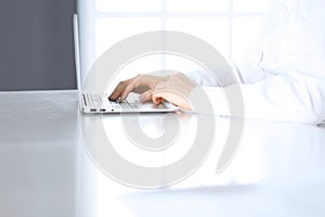 Close-up of business woman hands typing on laptop computer. Secretary at work in office