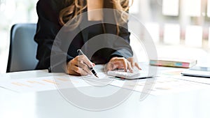 Close up business woman hands using calculator to calculate tax, accounting, statistics and accounting analyst