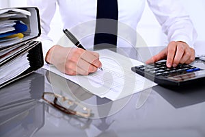 Close up of business woman making report, calculating or checking balance.