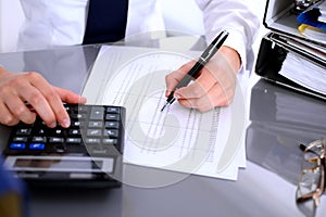 Close up of business woman making report, calculating or checking balance.